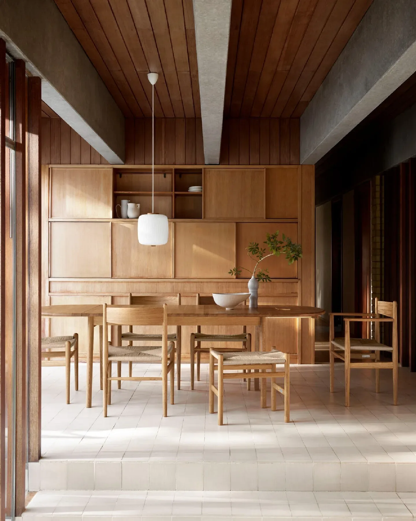 A Scandinavian-design dining room with a wooden table and chairs.