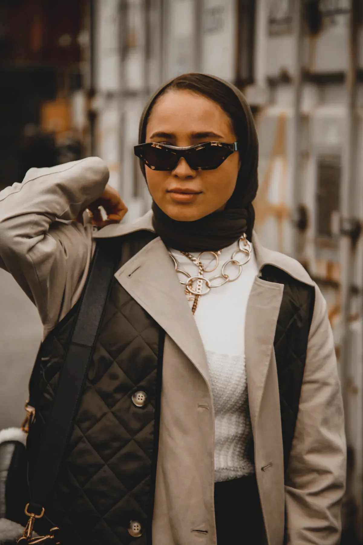 A Scandinavian woman wearing sunglasses and a trench coat.
